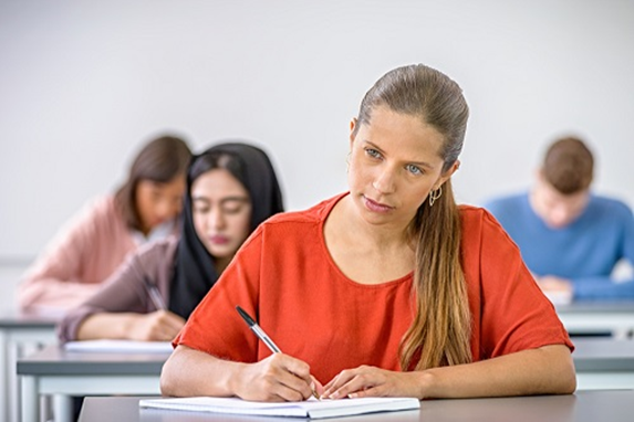 girl student writing exam thinking
